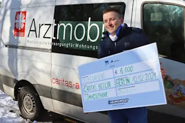 Auf diesem Foto sehen Sie Aaron Troschke, der im Namen von Homeday den Spendenscheck überreicht.