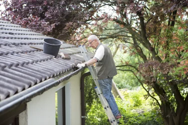 Hier sehen Sie das Bild eines Mannes, der das Leiterrecht im Nachbarschaftsrecht nutzt.