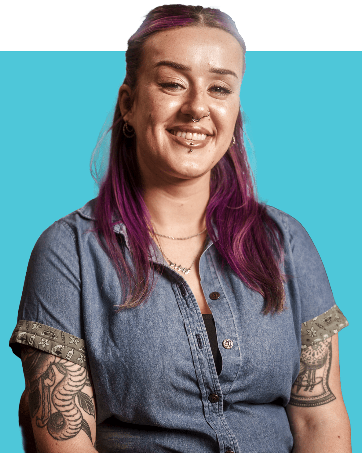 A smiling young woman in a denim shirt.