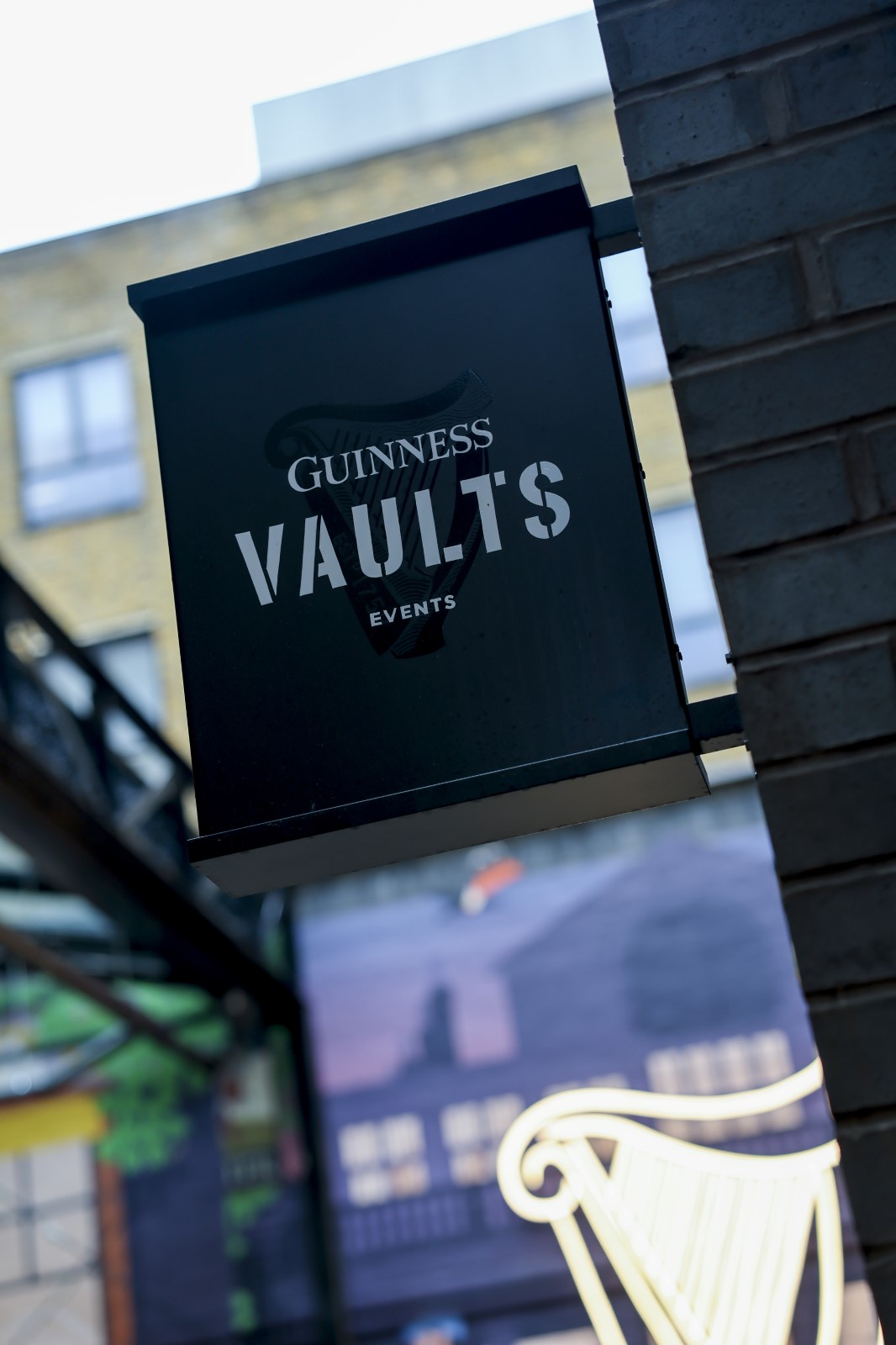 A view of the sign on the outside of the Guinness Vaults, with a black background and white text