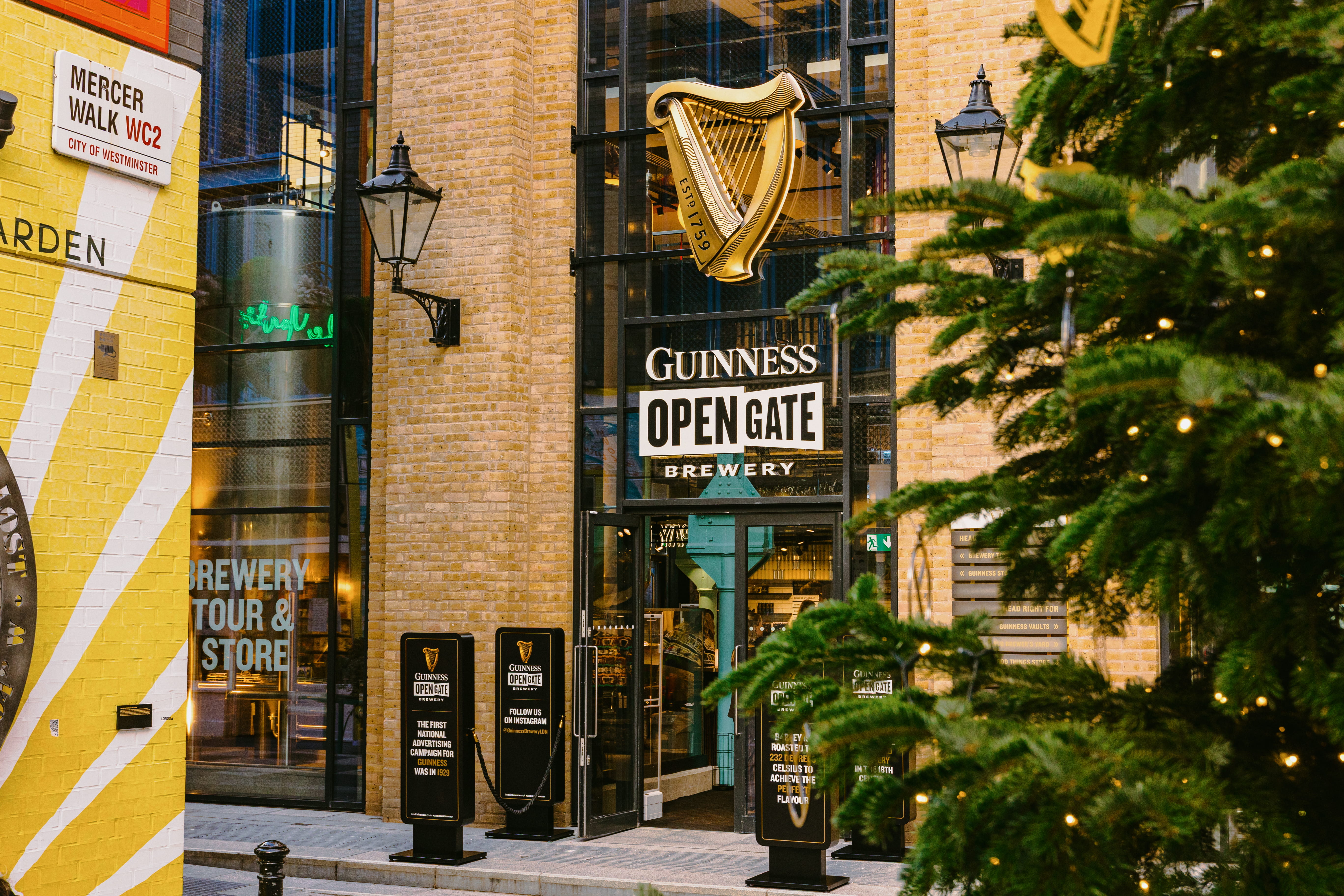 The Guinness Open Gate Brewery in Covent Garden entrance with the side of a Christmas tree in the foreground
