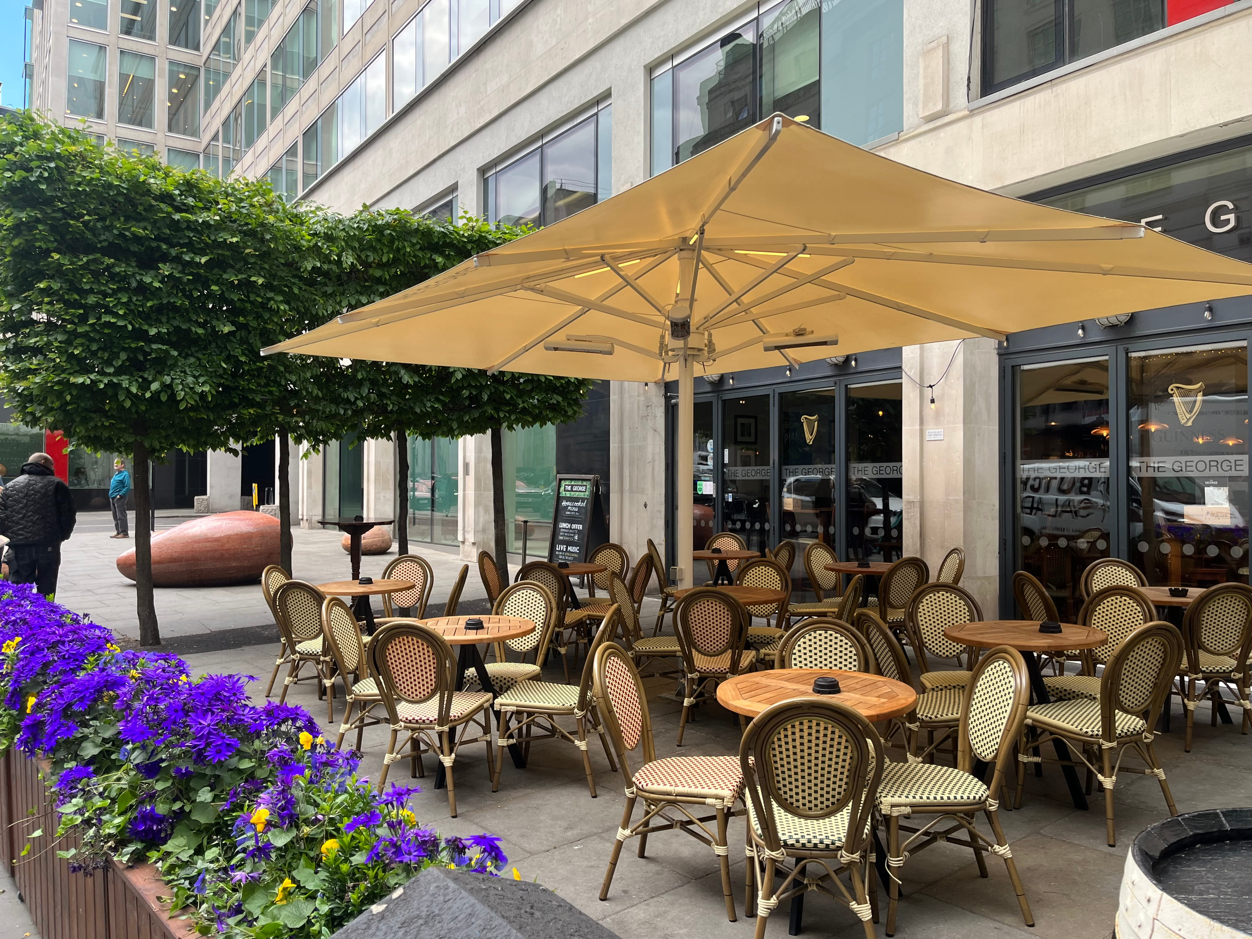 The outdoor seating area at The George pub in Covent Garden, complete with tables, chairs and parasols