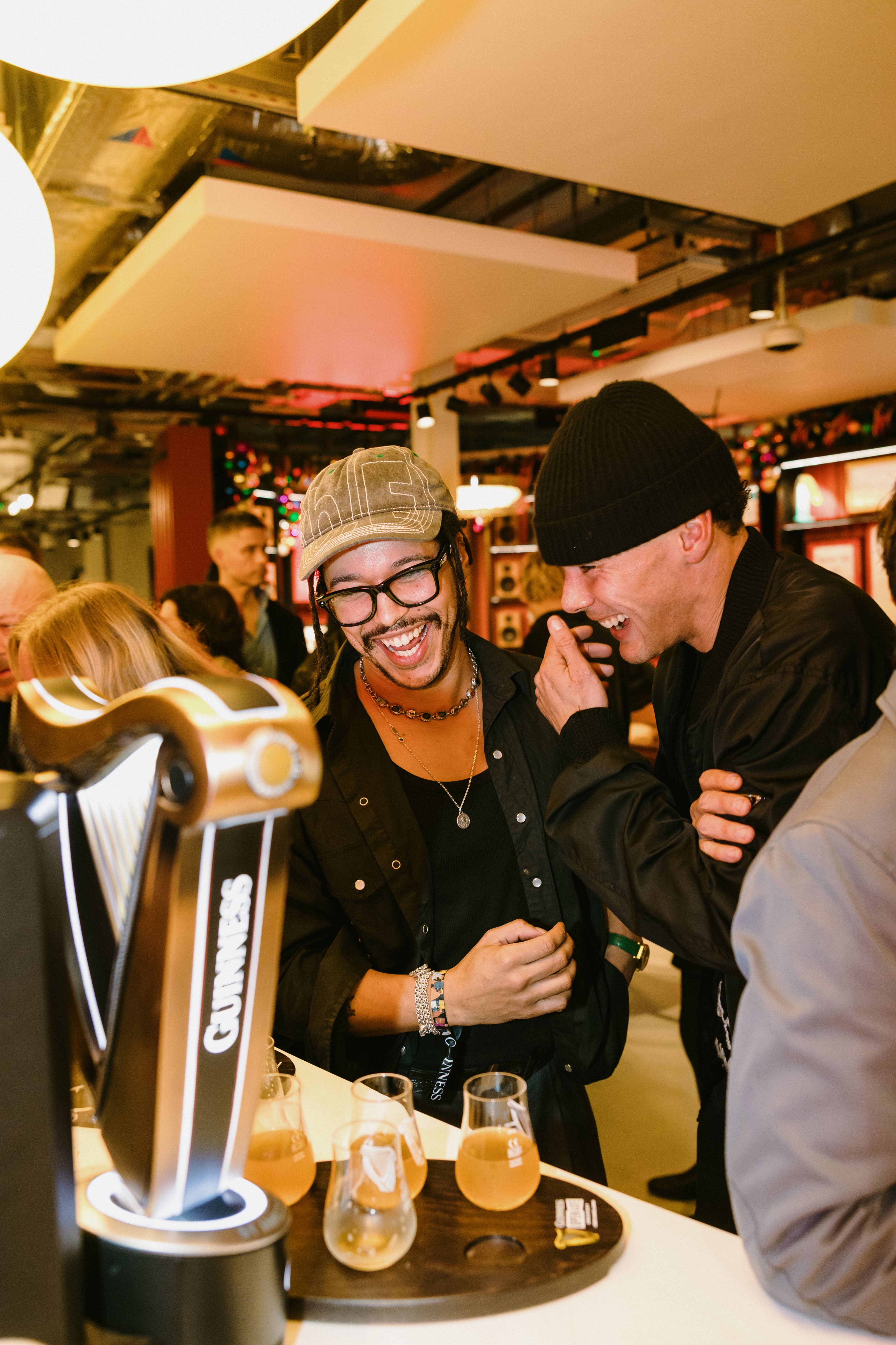 Two men laugh at the bar at their private event in the Guinness Vaults event space in London