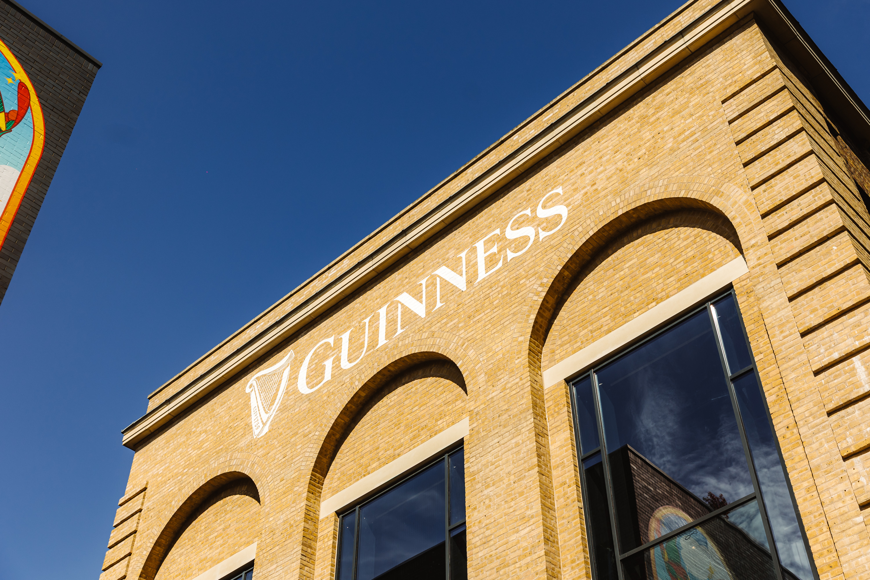 A large brick building with Guinness painted across the top in white paint