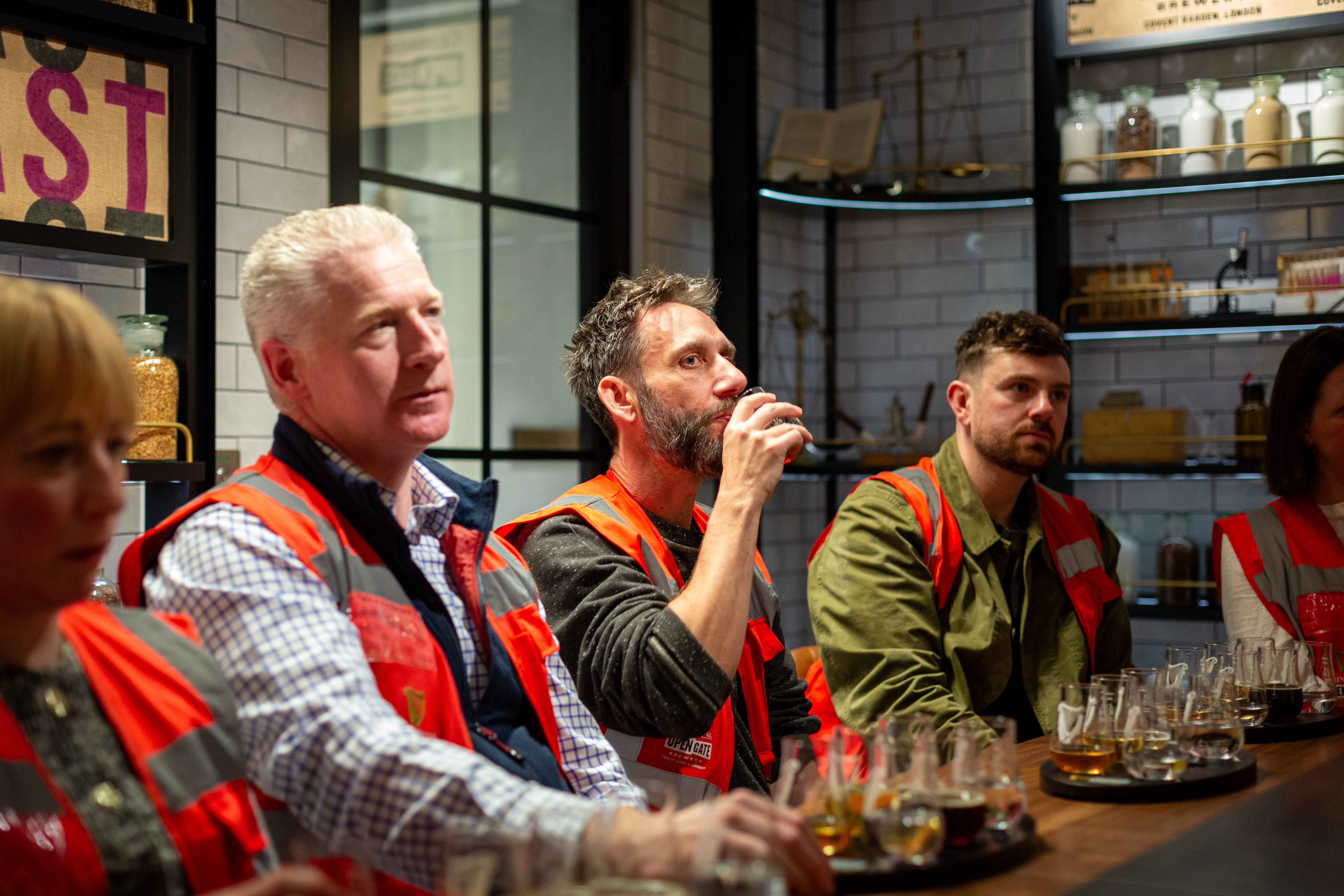 3 men sit around the brewer's table enjoying their beer tasting with craft beers brewed at the Guinness brewery in central London