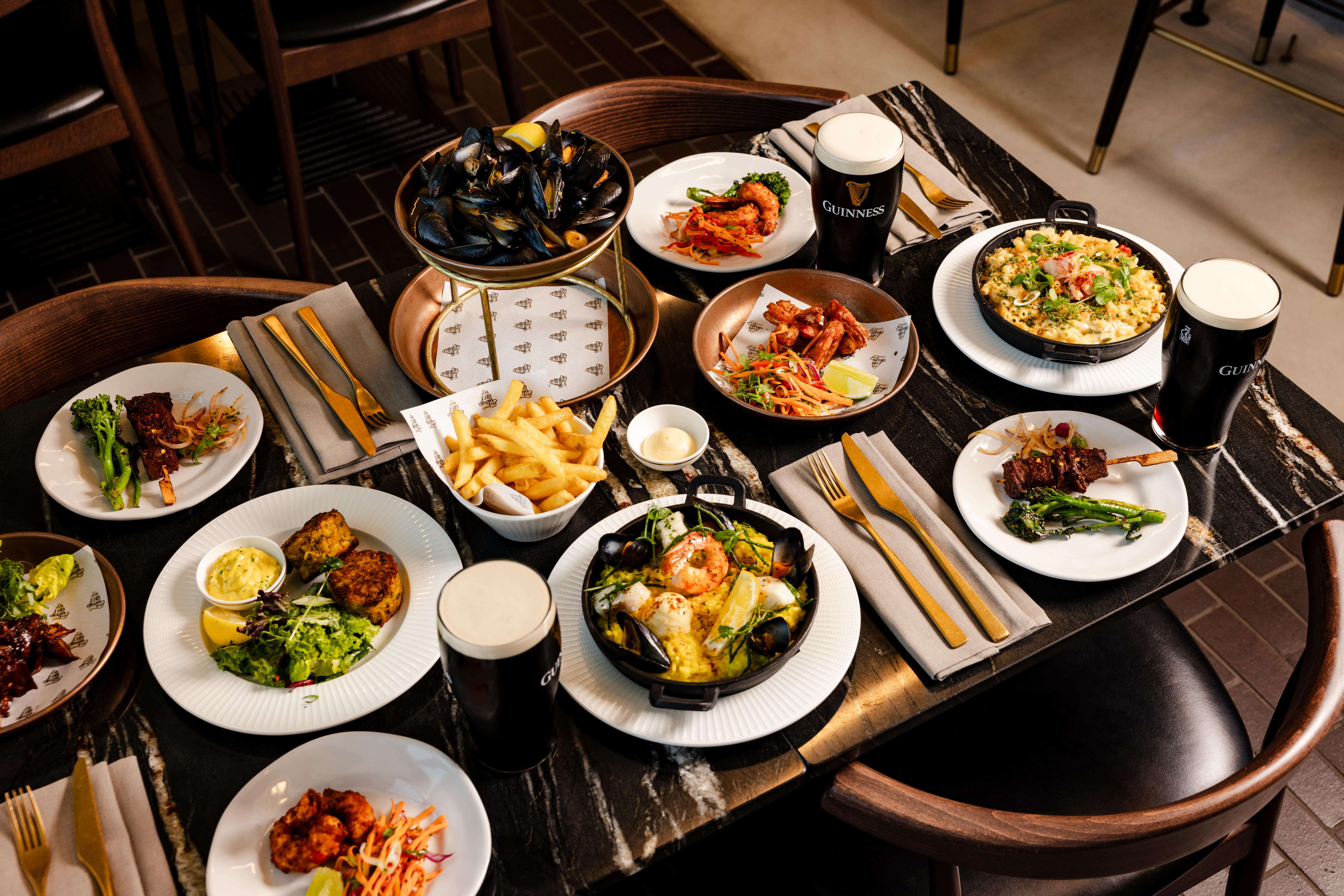 A table is laid with a delicious spread of seafood dishes paired with beers from the brewery and Guinness at the rooftop restaurant in Covent Garden