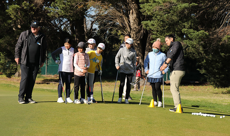 Some of Victoria's best junior girl golfers watch on during a chipping drill demonstration.