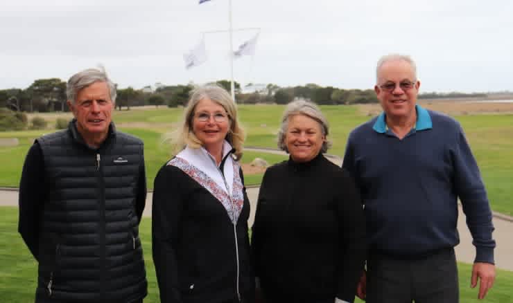 Four winning players (two men and two women) standing on the golf course