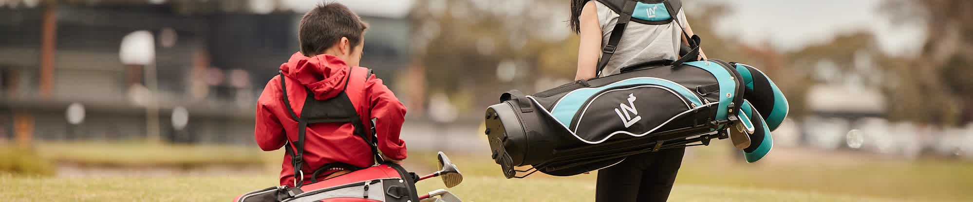 two kids walking away with golf bags