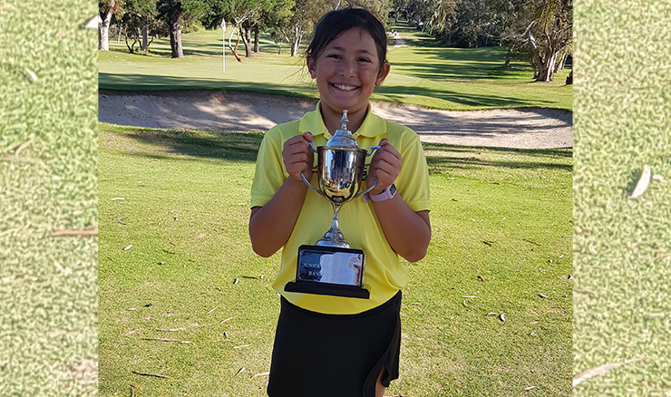 Genna proudly holding her junior club champion trophy.