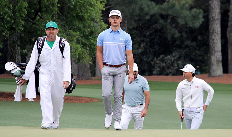 Harrison Crowe walking alongside caddie Andrew Tschuddin with Jason Day and Min Woo Lee trailing behind during their practice round.