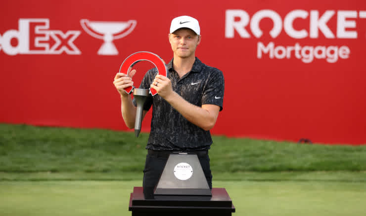 Cam Davis holds the Rocket Mortgage Classic trophy.