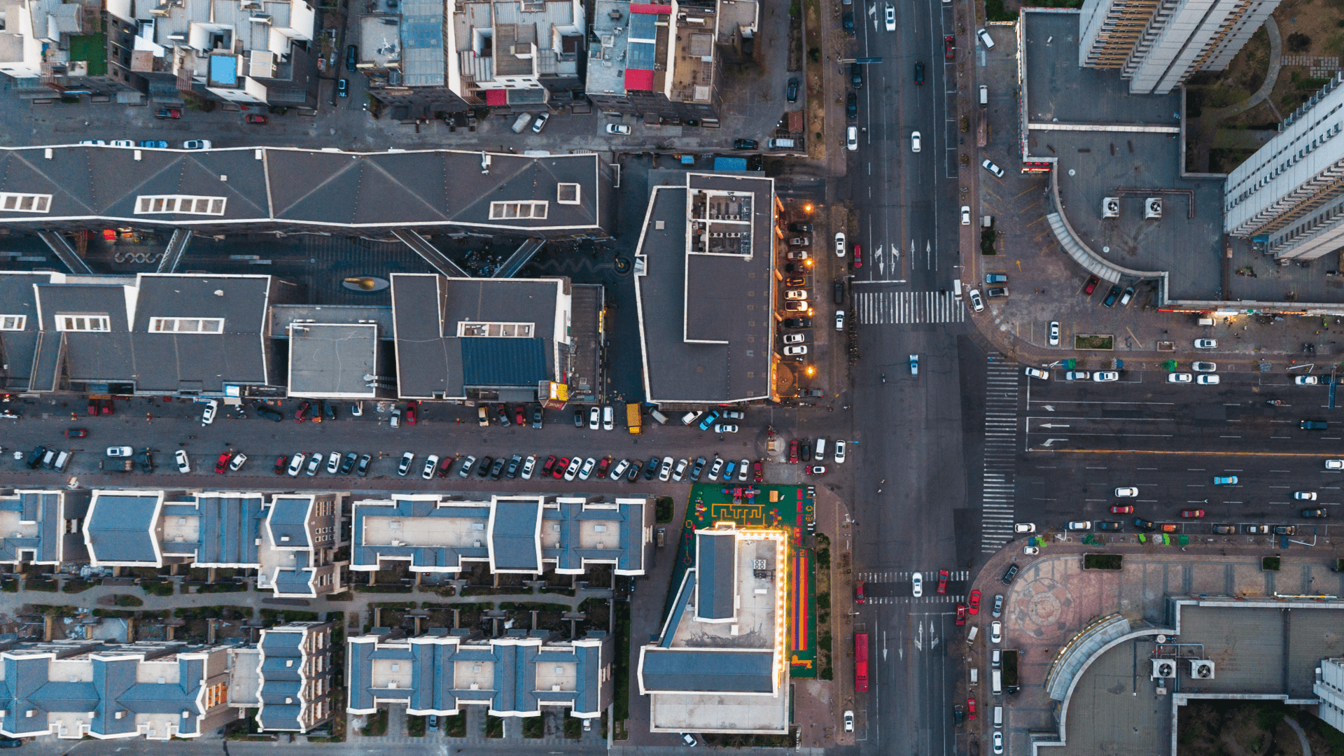 aerial view of several urban city blocks, mix of roads, very tall buildings, smaller buildings