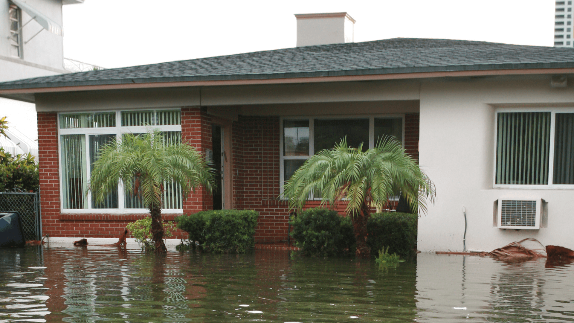 A flooded street in front of a house