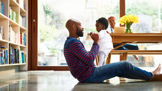 Father plays with his child while sitting on the floor