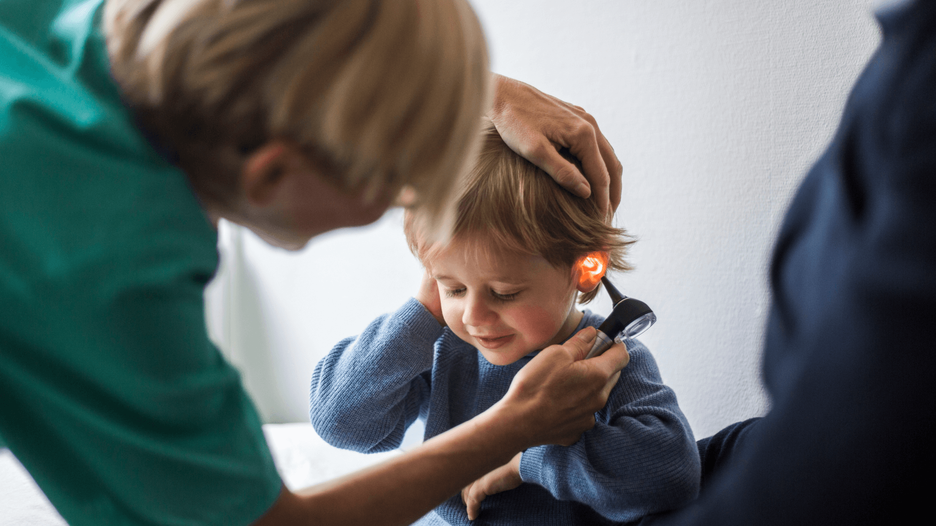 a doctor examines a boy's ears