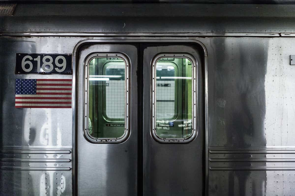 Subway doors and an American flag next to it.