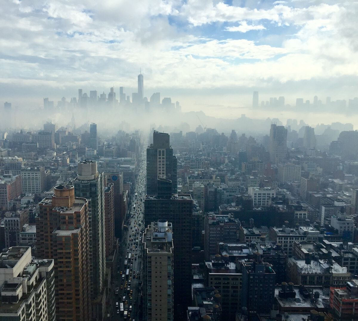 City scrapers bursting through clouds.