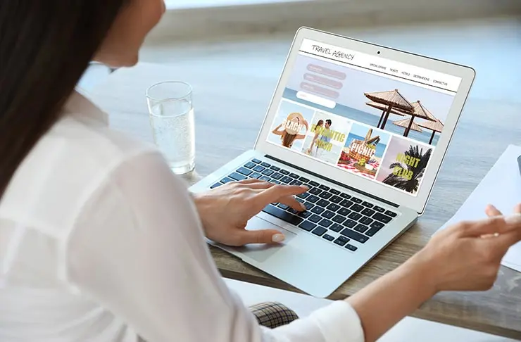 A woman booking travel on a laptop.