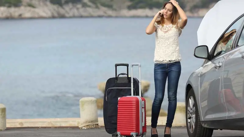 customer on cell phone with broken car on luggage