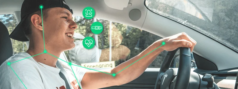 Person driving car with annotations meant to convey heart rate monitoring