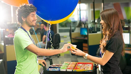 A man giving a candy to a female co-worker