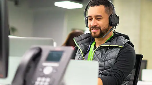 A man sitting at a computer with his headset on