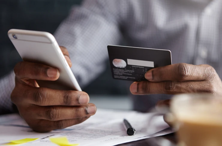 a person using a credit card to make a payment on his smartphone