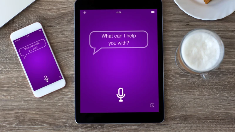 Tablet and phone displaying speech bubbles that read "What can I help you with?"