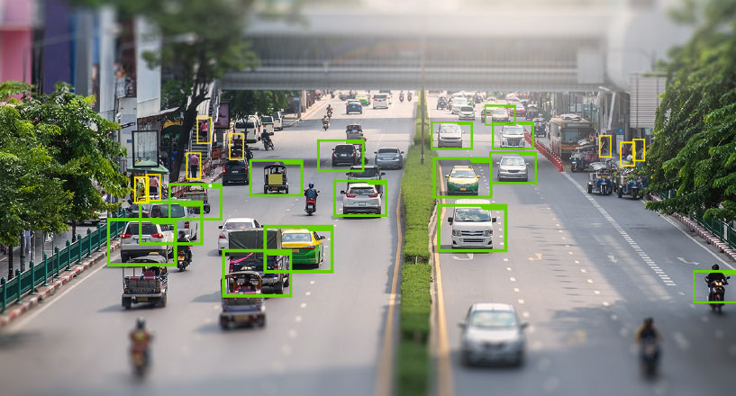 A busy street with traffic and people, which have been highlighted for AI data software