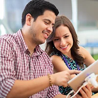 A man showing a woman something on a tablet screen