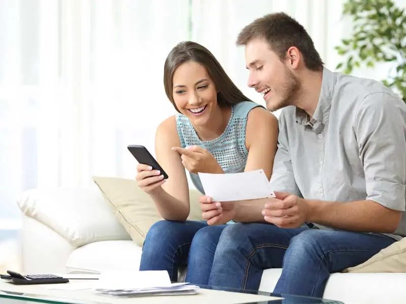 Millennial couple looking at banking information on phone