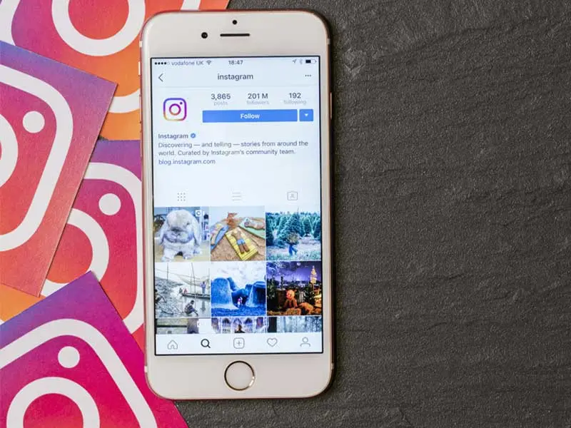Smartphone displaying instagram account open on grey background