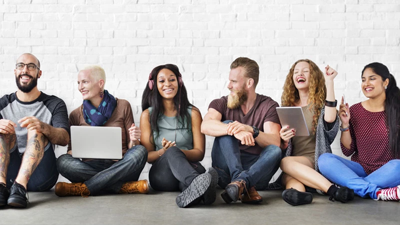 Photo of several young adults sitting on the ground