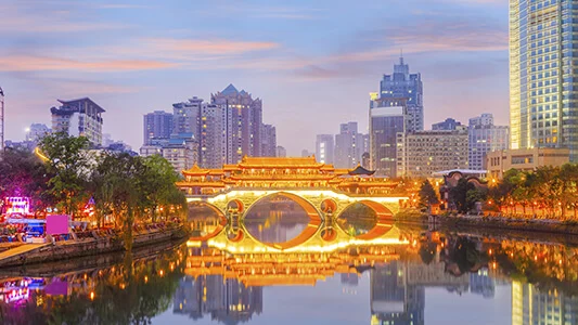 River going under lit bridge in China