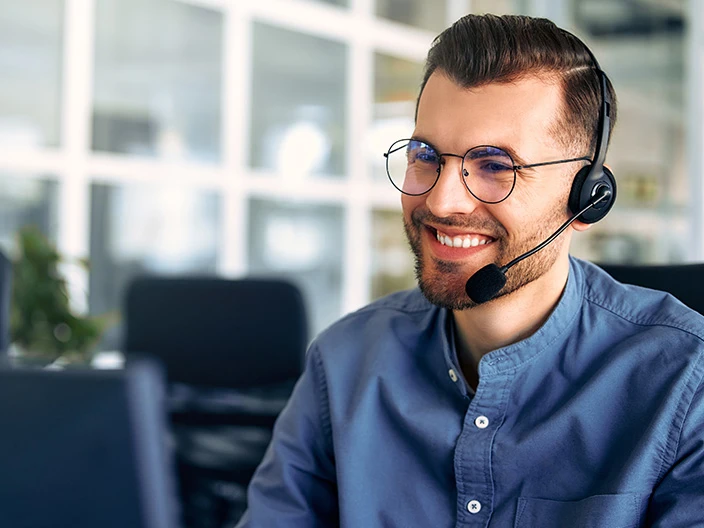 An IT Service Desk agent speaking to someone on a headset.