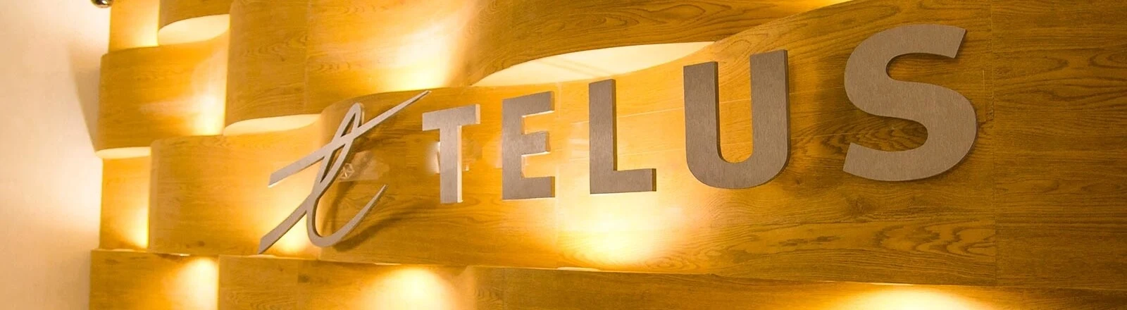 TELUS International logo against a wall in an office
