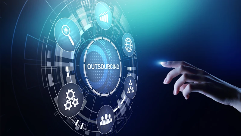 Hand reaching towards a digital interface that depicts the word "Outsourcing"