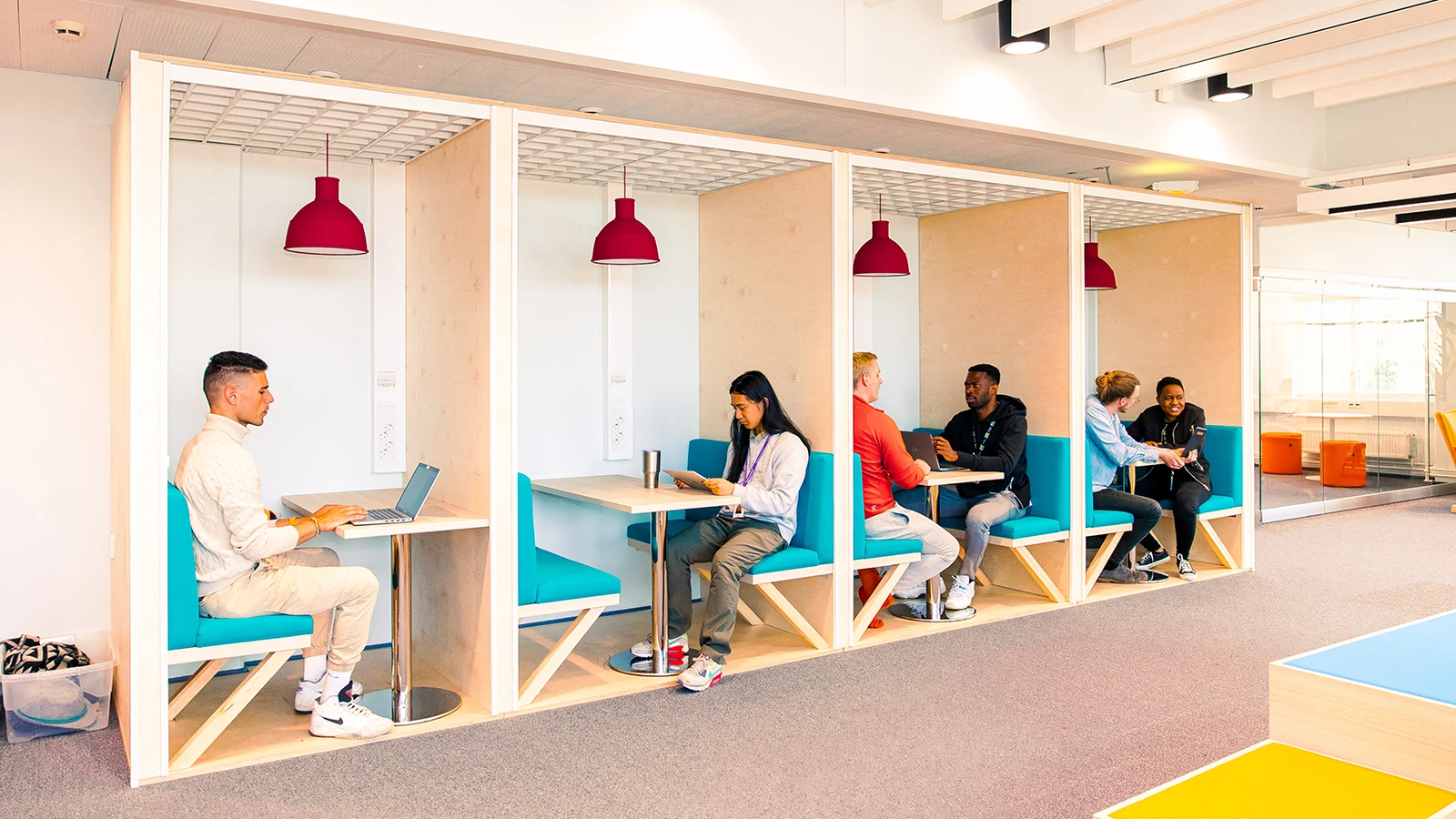 TELUS International employees sitting in cubbies at the Tampere office. 