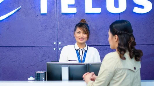 Two women having a conversation at a TELUS international office space in the Philippines