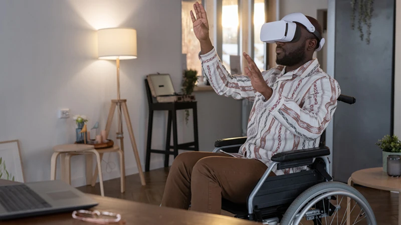 Person in wheelchair interacting with virtual reality headwear