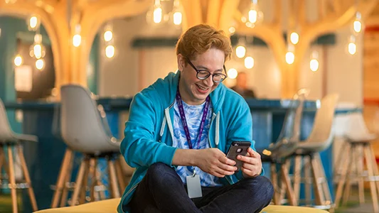 A man smiling at his phone