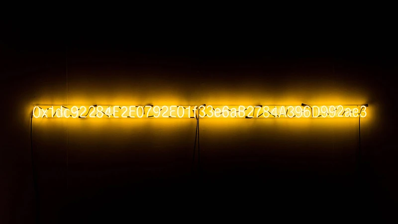 Artist Kevin Abosch's "Yellow Lambo" depicting a yellow neon sign that spells out 42 inline alphanumerics representing the blockchain contact address for the unique crypto-token
