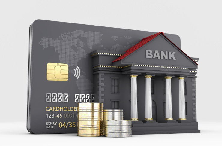 Bank card, coins and a model of a bank
