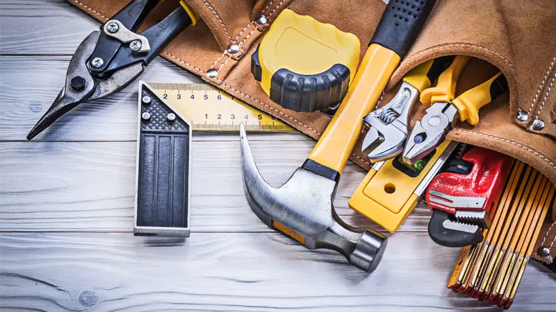 tool belt with various hammer, pliers rulers and wrench