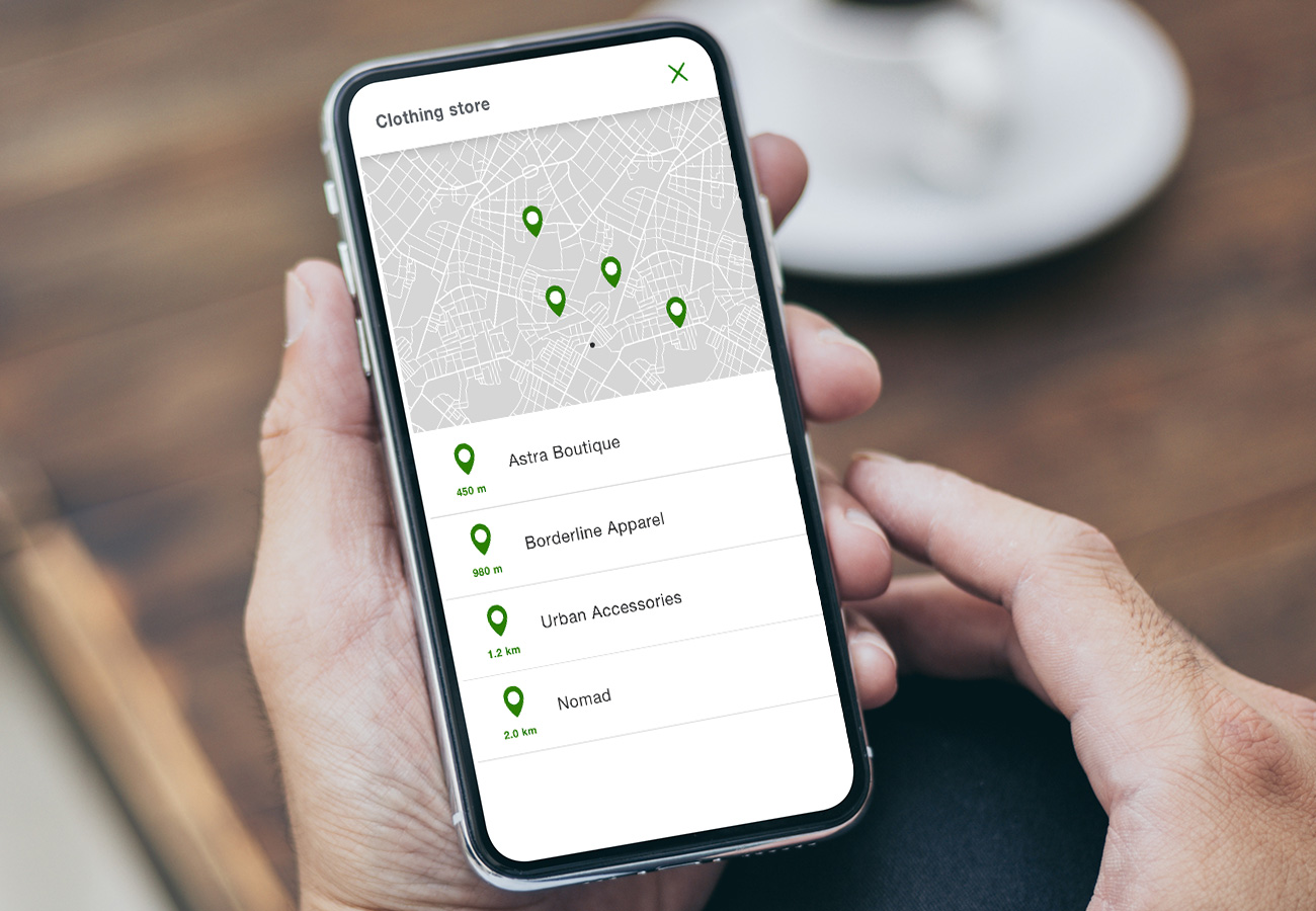 a smartphone showing the locations of clothing stores nearby on a map