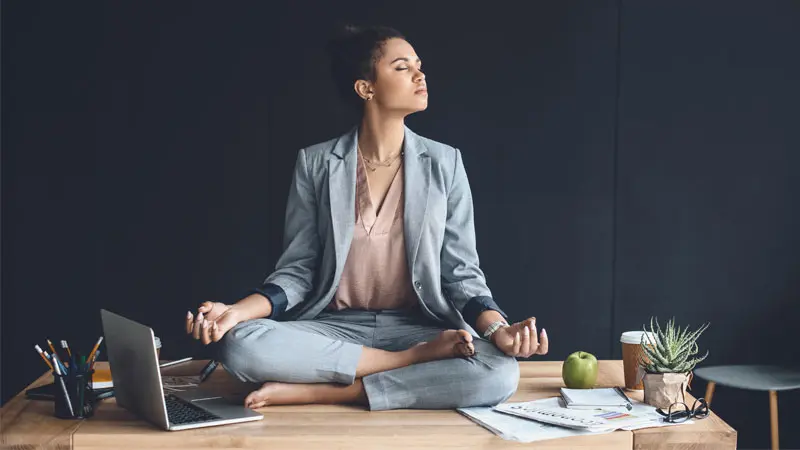 Woman meditating on her desk 