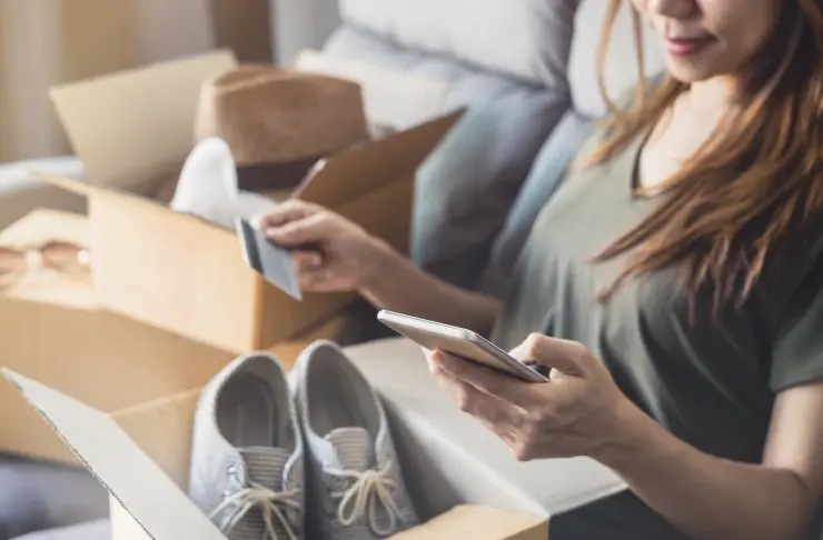 a woman with a credit card checking her smartphone