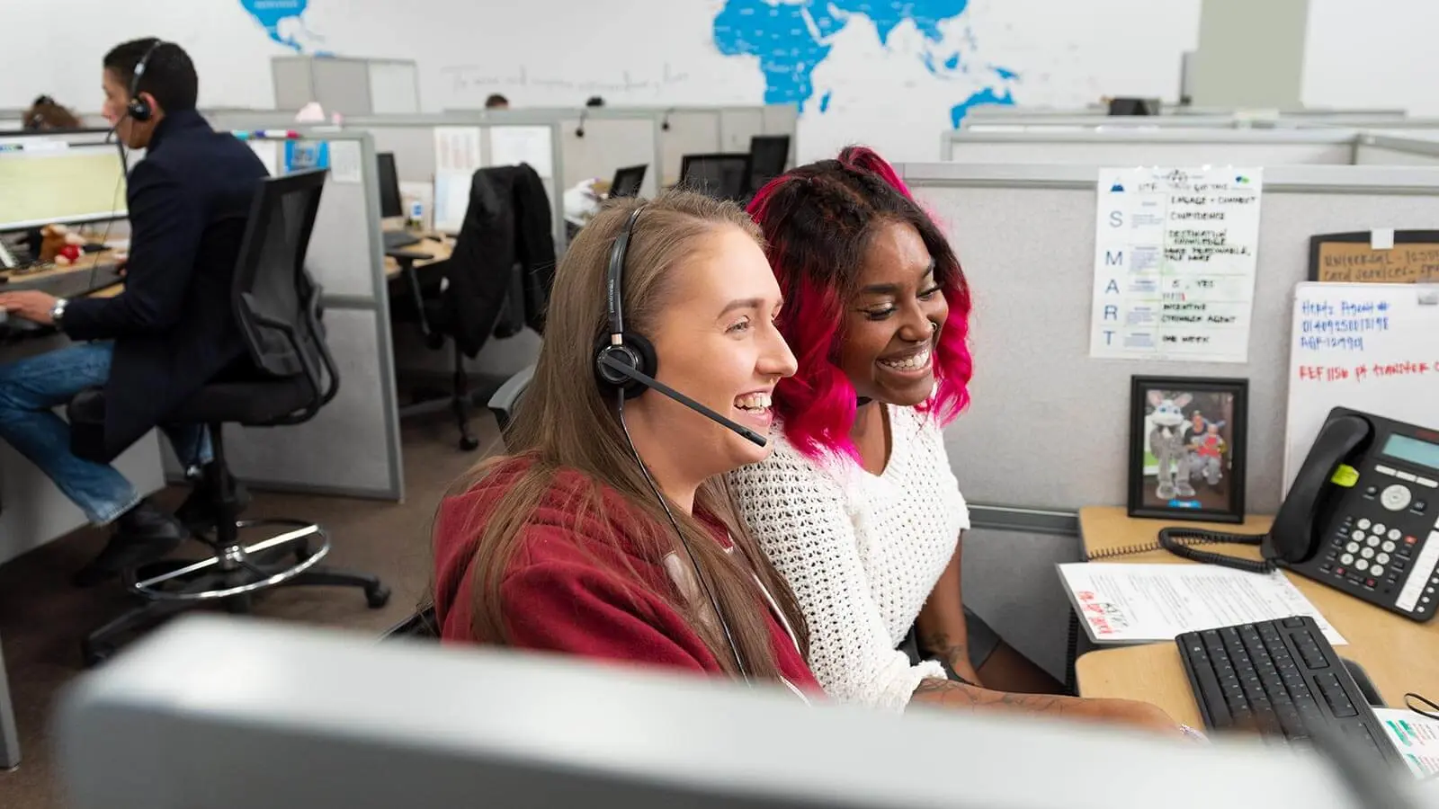 Two women smiling at a desk