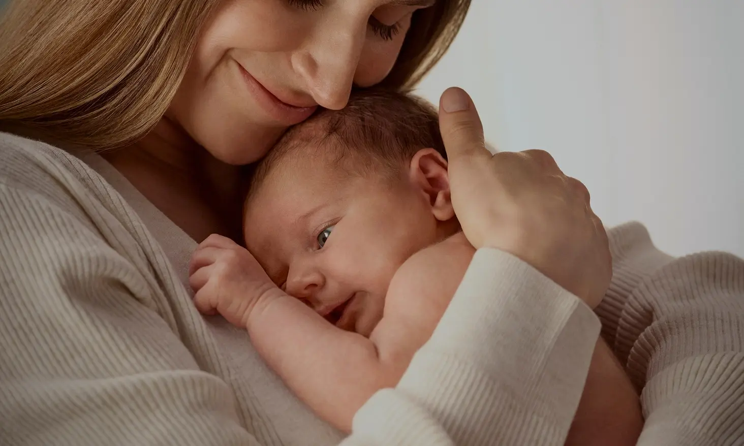 About Johnson’s® Baby banner, image of a mother smiling while gently hugging her baby.